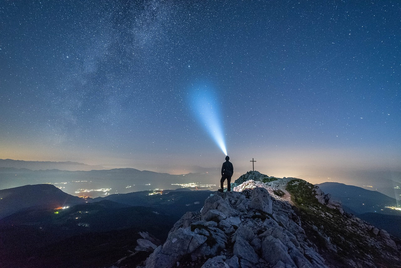 Man with a headlamp at starry night night